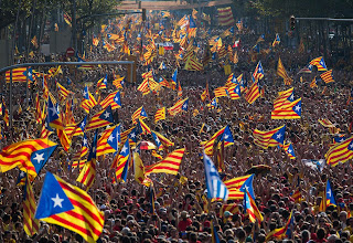A Catalan indepencence rally: thousands of people, carrying Estelada flags