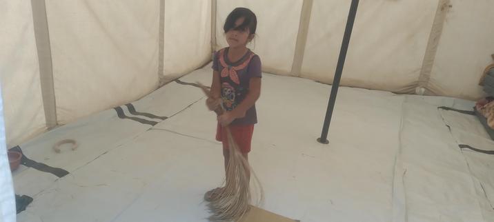 A small girl (Kinda?) stands in an empty, new looking, square white tent
