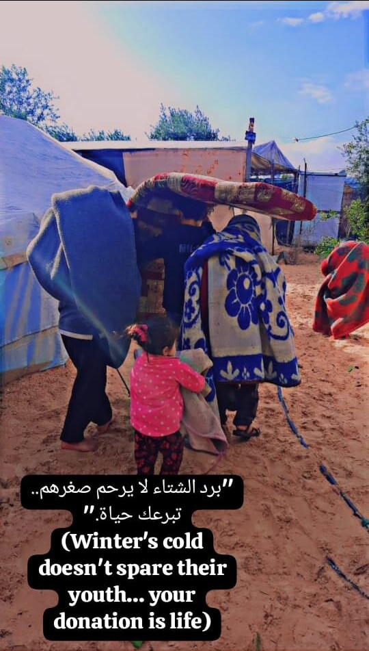 Nourhan andmembers of her familly walking through a camp in Gaza